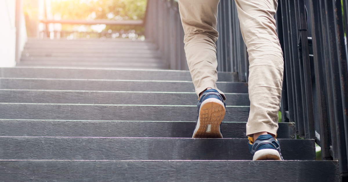a man in tan shoes and sneakers walking up an outdoor staircase 