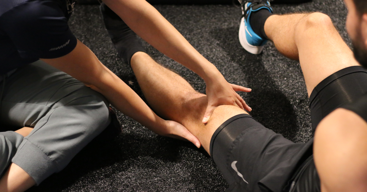 physiotherapist guiding clients knee through a nerve flossing exercise